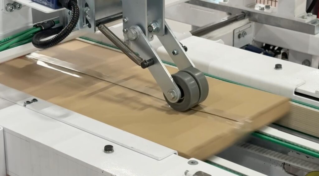 The end of the Edda Lotis packaging line showing a perfectly taped, sealed, and ERP-integrated labeled final flat-pack furniture box ready for logistics.
