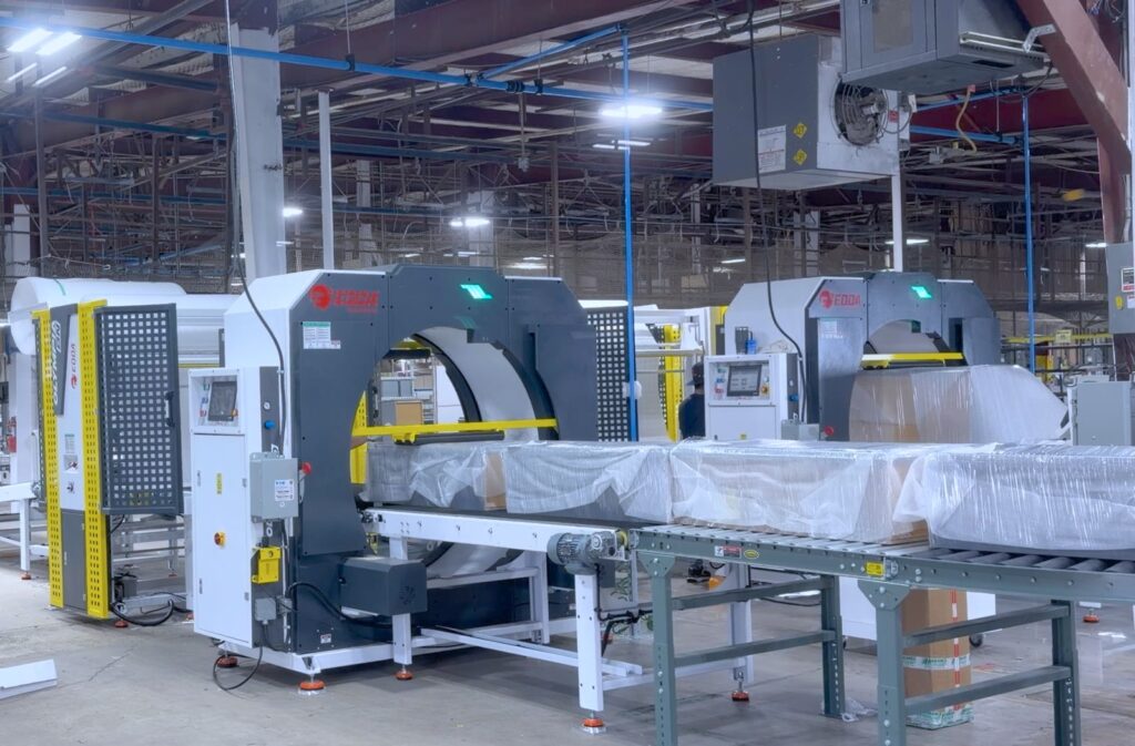 Edda Packaging horizontal stretch wrapping machine packaging wooden furniture components in an industrial facility.